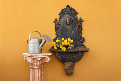 Close-up of yellow flower pot against wall