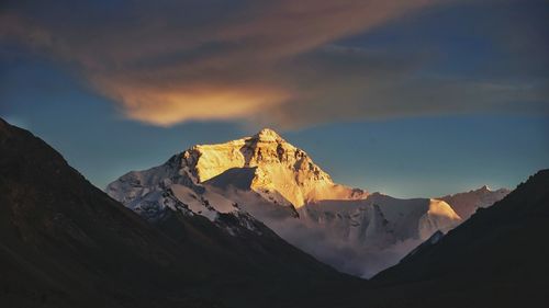 Scenic view of snowcapped mountains against sky during sunset