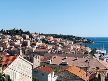 High angle view of townscape by sea against clear sky