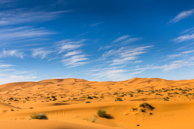 Scenic view of desert against blue sky