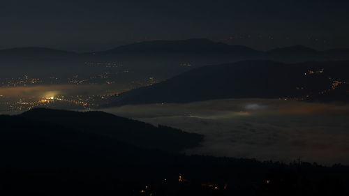 Scenic view of silhouette mountains against sky at night