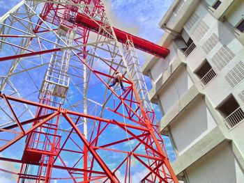 Low angle view of man climbing on communications tower