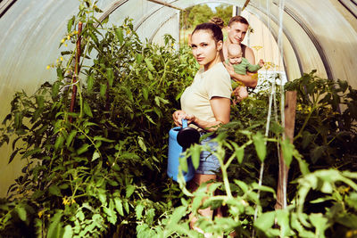 Portrait of woman standing amidst plants