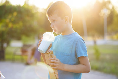 Side view of boy holding water bottle
