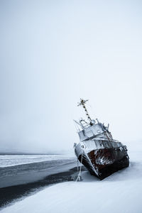 Sailboat in sea against sky during winter