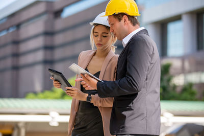 Woman wearing mask while standing on mobile phone