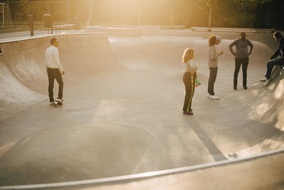 Full length of multi-ethnic friends at skateboard park