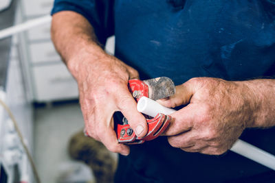 Midsection of man holding work tool