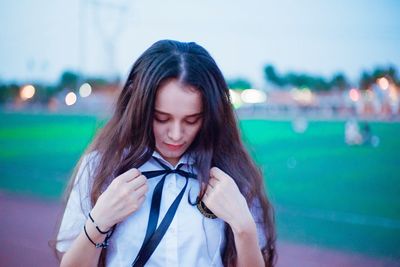 Close-up of beautiful young woman standing against sky