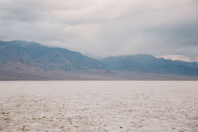 View of desert against cloudy sky