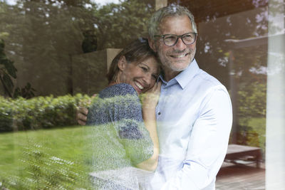Happy mature couple looking out of window