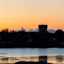 Silhouette buildings against clear sky during sunset