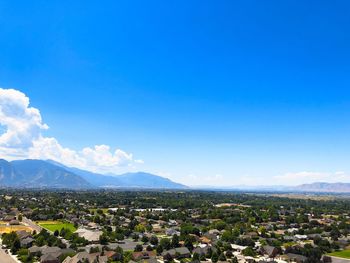 Aerial view of townscape against blue sky