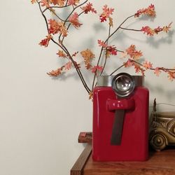 Close-up of red flower on table against wall