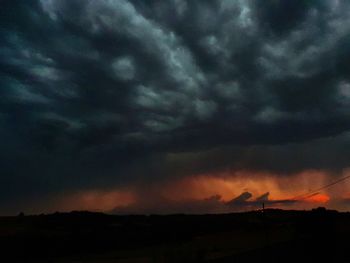 Silhouette of landscape against cloudy sky