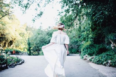 Rear view of woman walking by plants