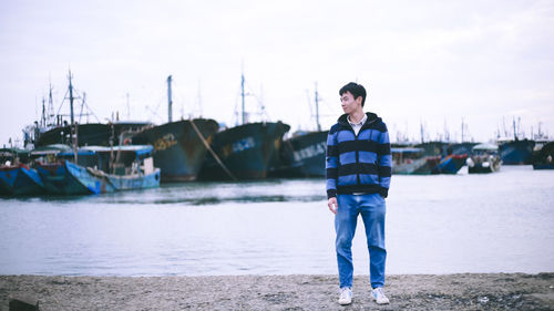 Portrait of young man standing in sailboat