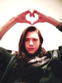 Close-up portrait of young woman with heart shape