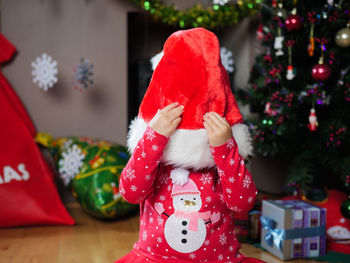 Close-up of baby girl wearing santa hat at home