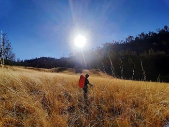 Woman on field against bright sun