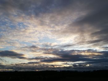 Silhouette of landscape against cloudy sky