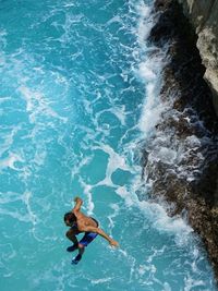 High angle view of man jumping in sea