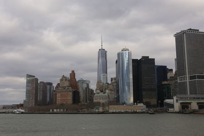 Modern buildings in city against cloudy sky