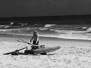 Man sitting on boat at beach