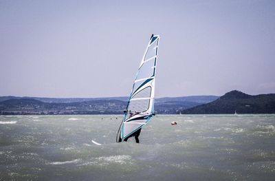 Sailboat in sea against clear sky