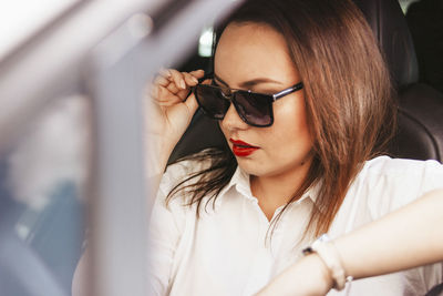 Woman wearing sunglasses in car