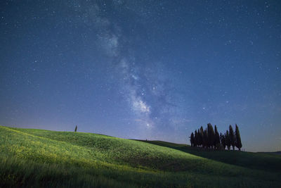 Scenic view of green landscape against star field at night