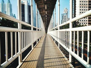 Footbridge leading towards modern buildings in city