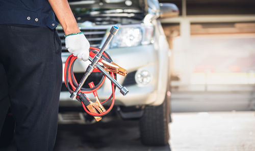 Midsection of man holding car