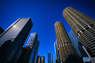 Low angle view of modern buildings against clear blue sky