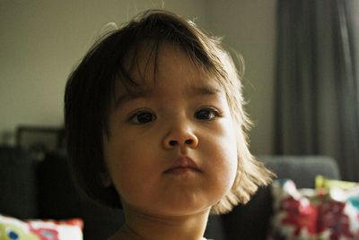 Close-up portrait of cute girl at home