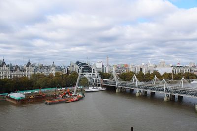 Bridge over river against sky in city