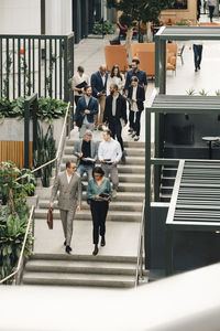 High angle view of male and female entrepreneurs climbing staircase
