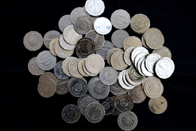 High angle view of coins on black background