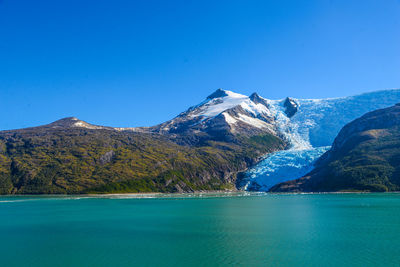 Scenic view of lake against clear blue sky