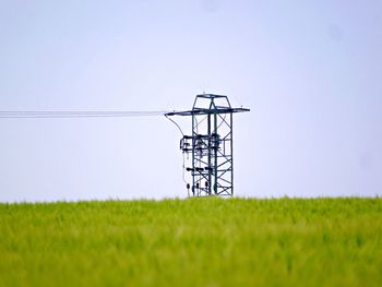 Electricity pylon on field against sky