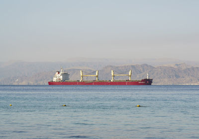 Ship sailing on sea against clear sky