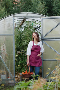 Young woman standing amidst plants