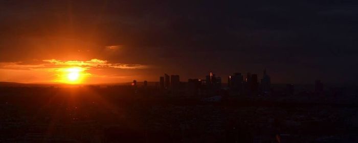 Skyscrapers in city at sunset