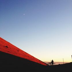 Silhouette of people against clear sky at sunset