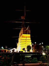 Illuminated traditional windmill against sky at night