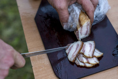 Midsection of person preparing food on barbecue grill