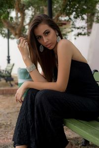 Portrait of a beautiful young woman sitting outdoors