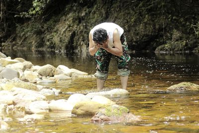 Men washing face in river