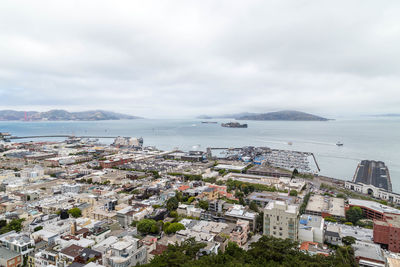 High angle view of townscape by sea against sky