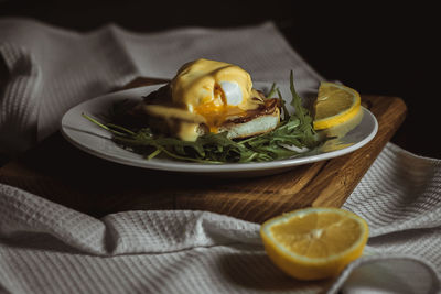 Eggs benedict and poached hollandaise sauce with arugula and lemon. delicious food for breakfast. 